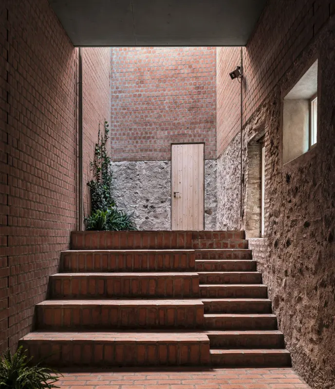 Atrio y escaleras Clos Pachem HArquitectes – escaleras en el atrio de ladrillo