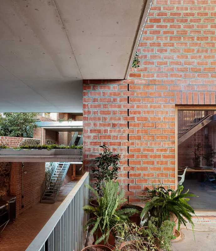 Pasarela exterior y jardineras Clos Pachem HArquitectes – pasarela exterior junto a pared de ladrillo