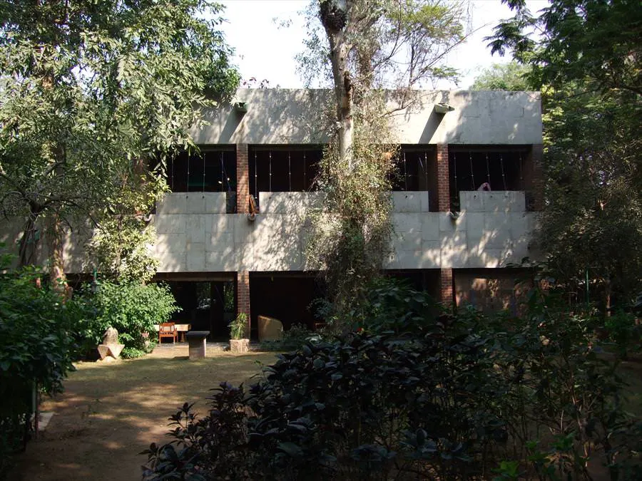 Villa Sarabhai – fachada entre árboles Fachada entre árboles y plataformas de sombra en Villa Sarabhai
