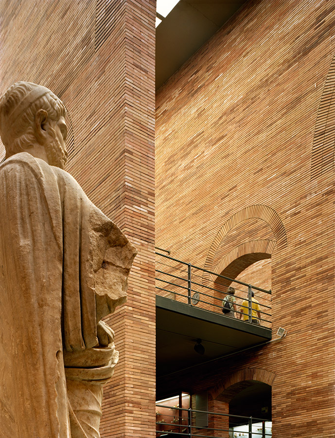 Detalle de estatua y muro de ladrillo Detalle de estatua romana sobre fondo de ladrillo en el Museo Nacional de Arte Romano